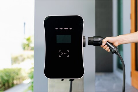 Closeup hand insert ev plug progressive electric car charging station